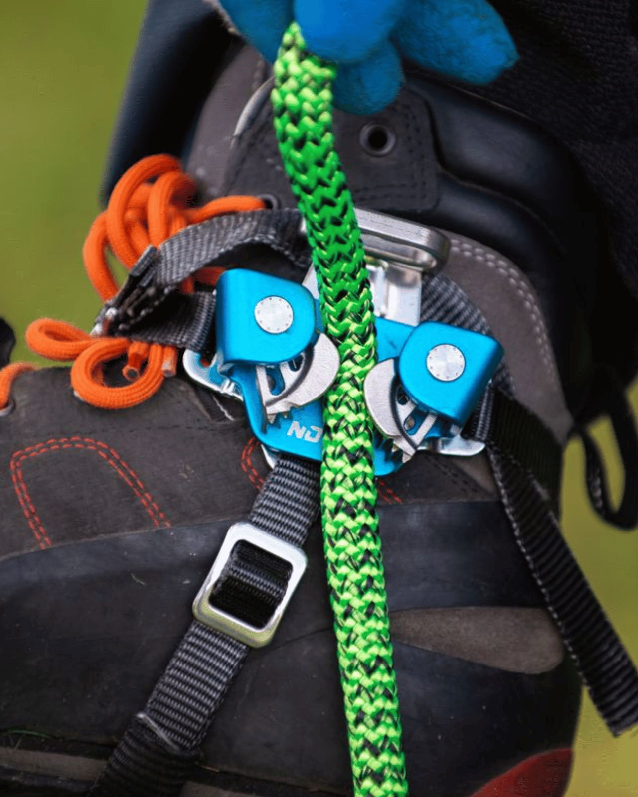 Climbing gear attached to a boot with a green rope.