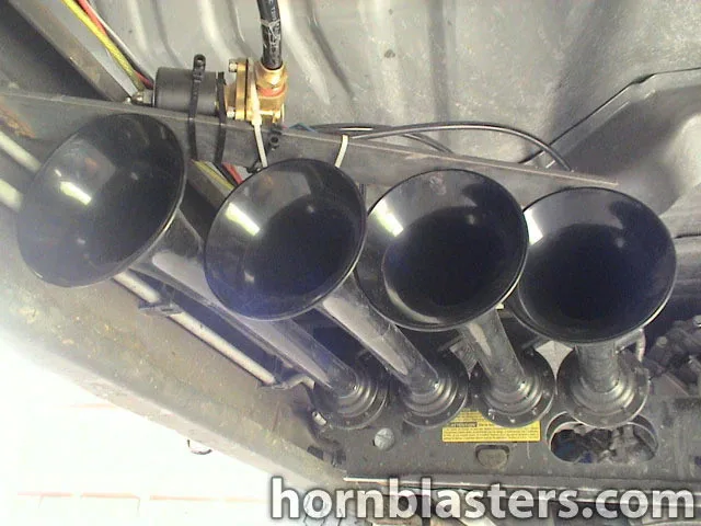Four black train horn bells mounted under truck