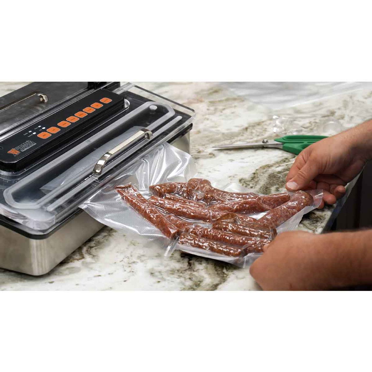 Person sealing meat in a vacuum bag with a vacuum sealer on a countertop.