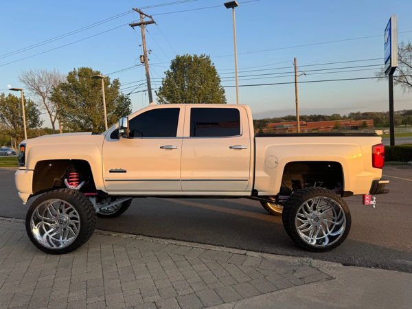 Side profile Brianna's lifted Silverado High Country with pink suspension and chrome wheels photo 5
