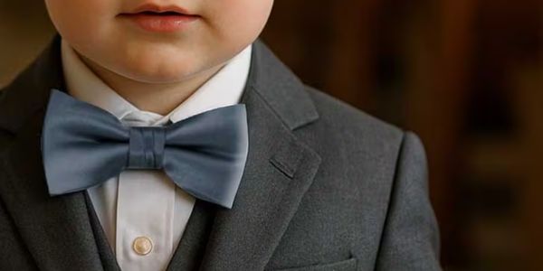 Ring bearer wearing a dusty blue bow tie with a gray suit