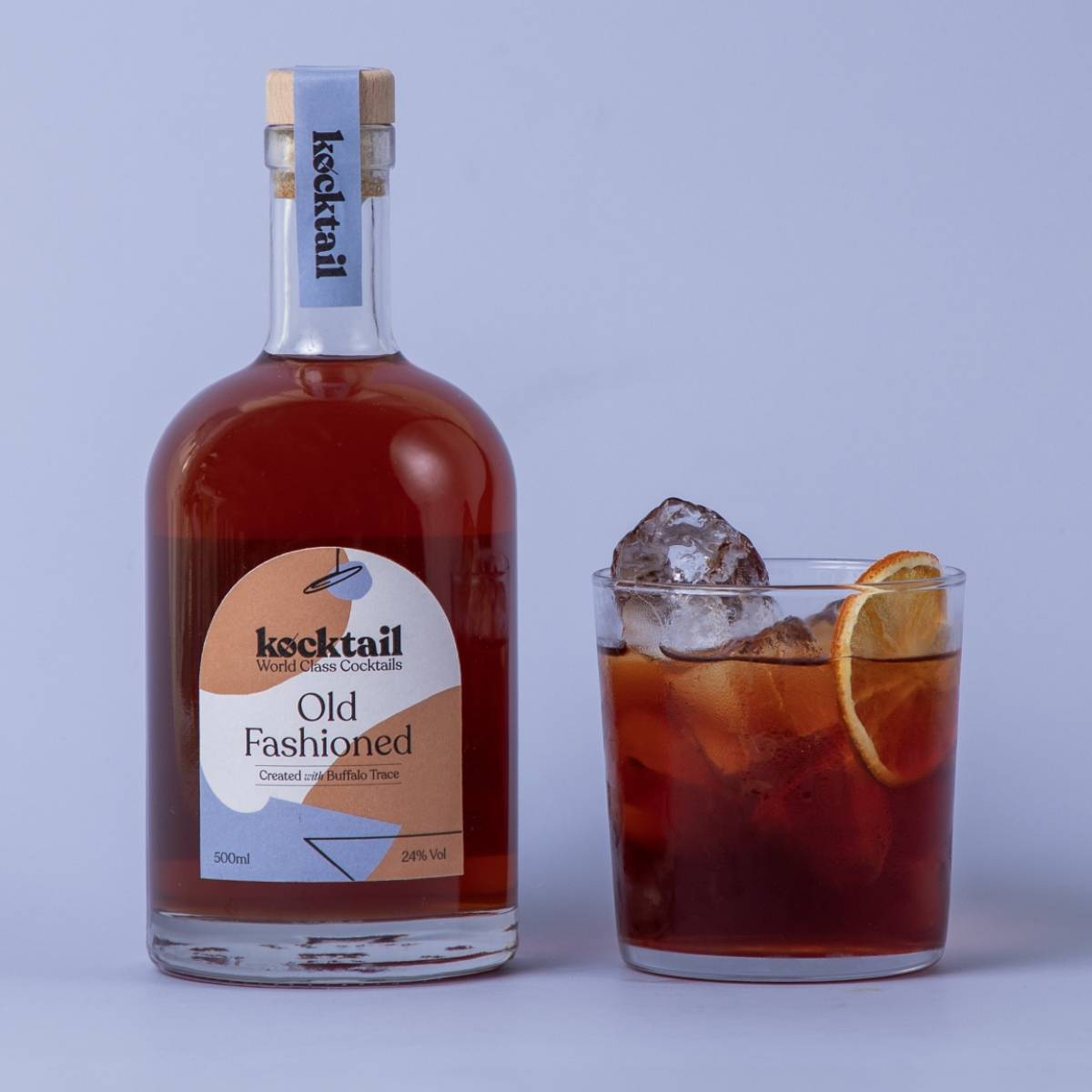 Old Fashioned cocktail and bottle on blue background