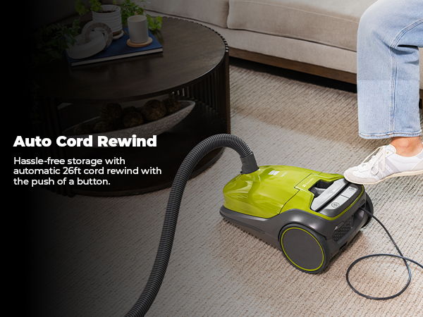 Vacuum cleaner with auto cord rewind feature on a carpeted floor.