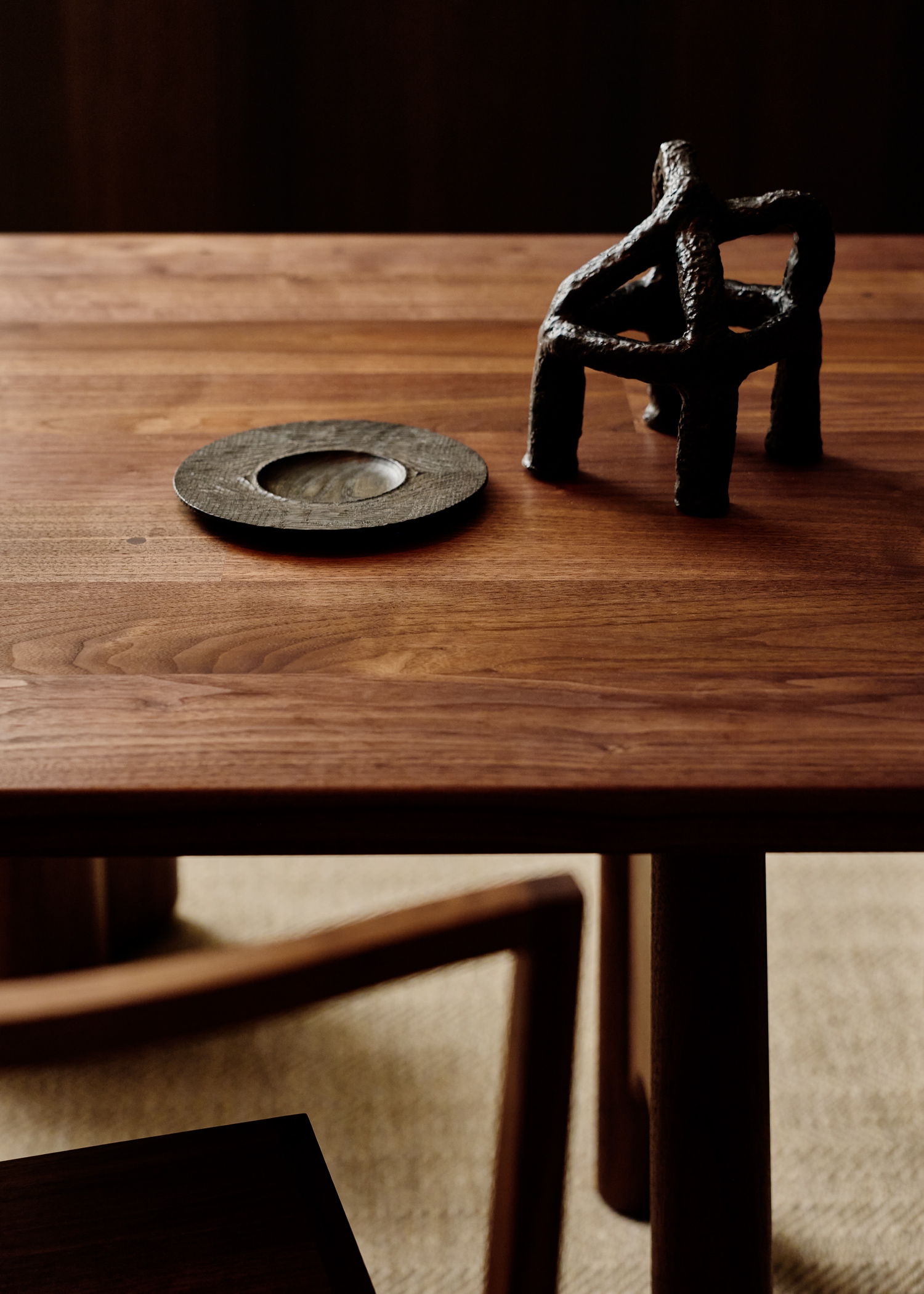 Wooden table with a decorative plate and a small sculpture.