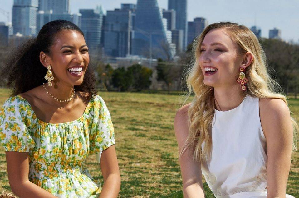 Laura Foote Designs statement earrings  on two models in the park.