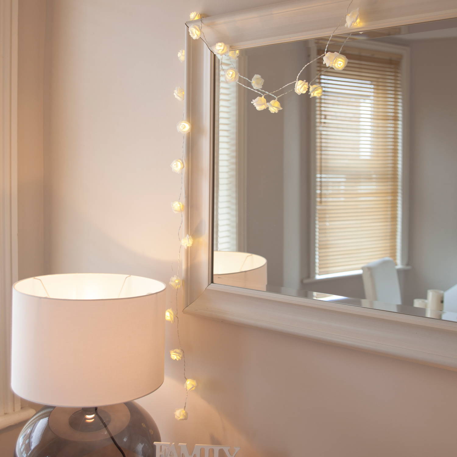 30 warm white led rose fairy lights on clear cable hanging from mirror frame edge