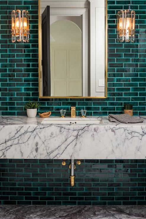 Emerald colored bathroom with gold bathroom accessories. 