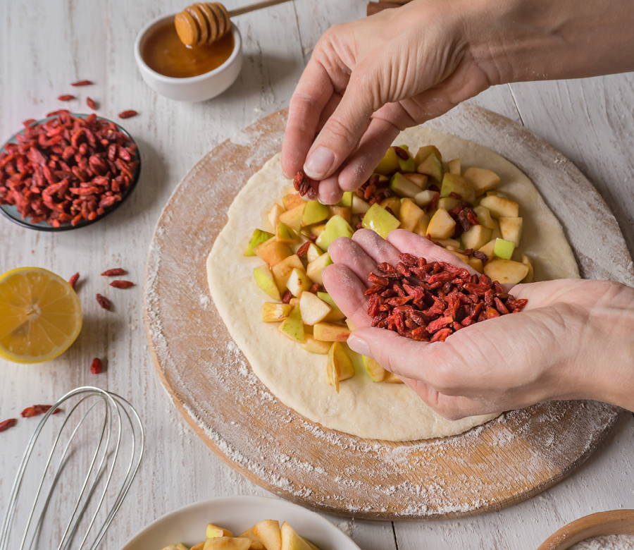 hand holding goji berries while preparing baked goods