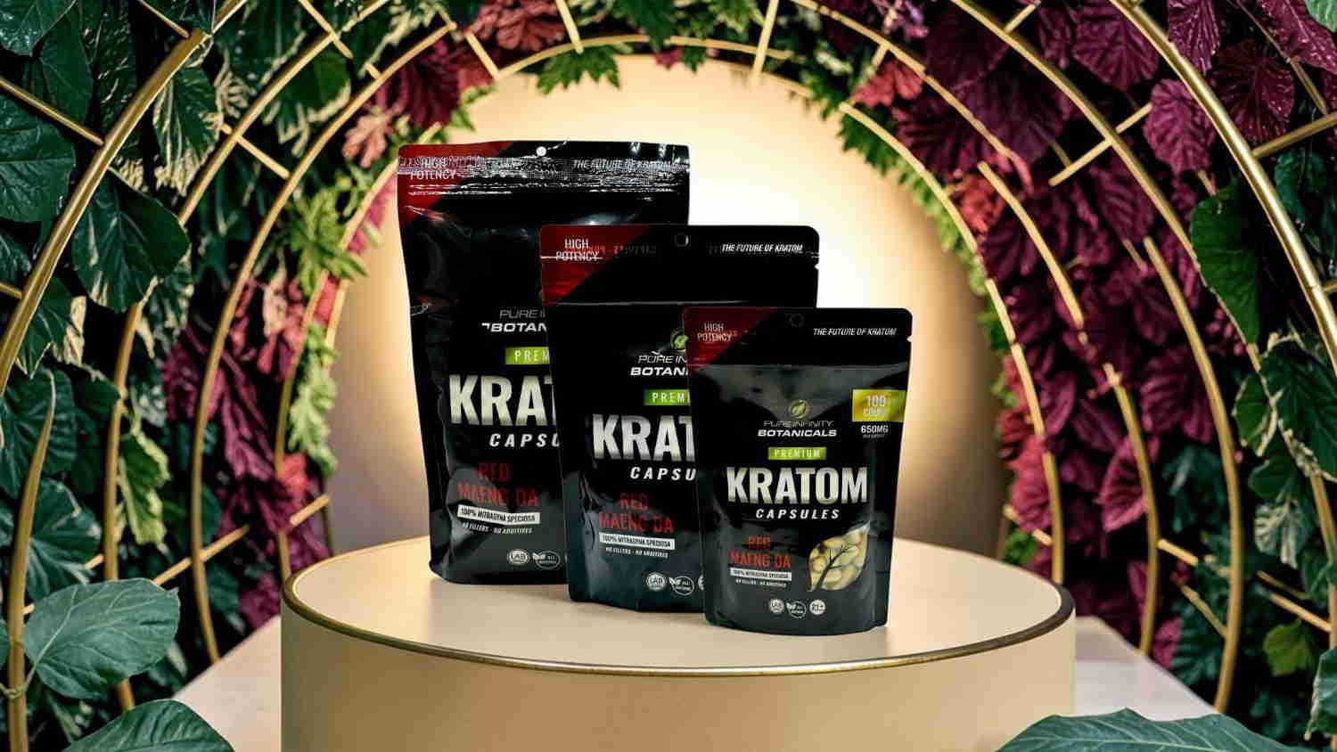 Three bags of kratom on a pedestal with a floral background.