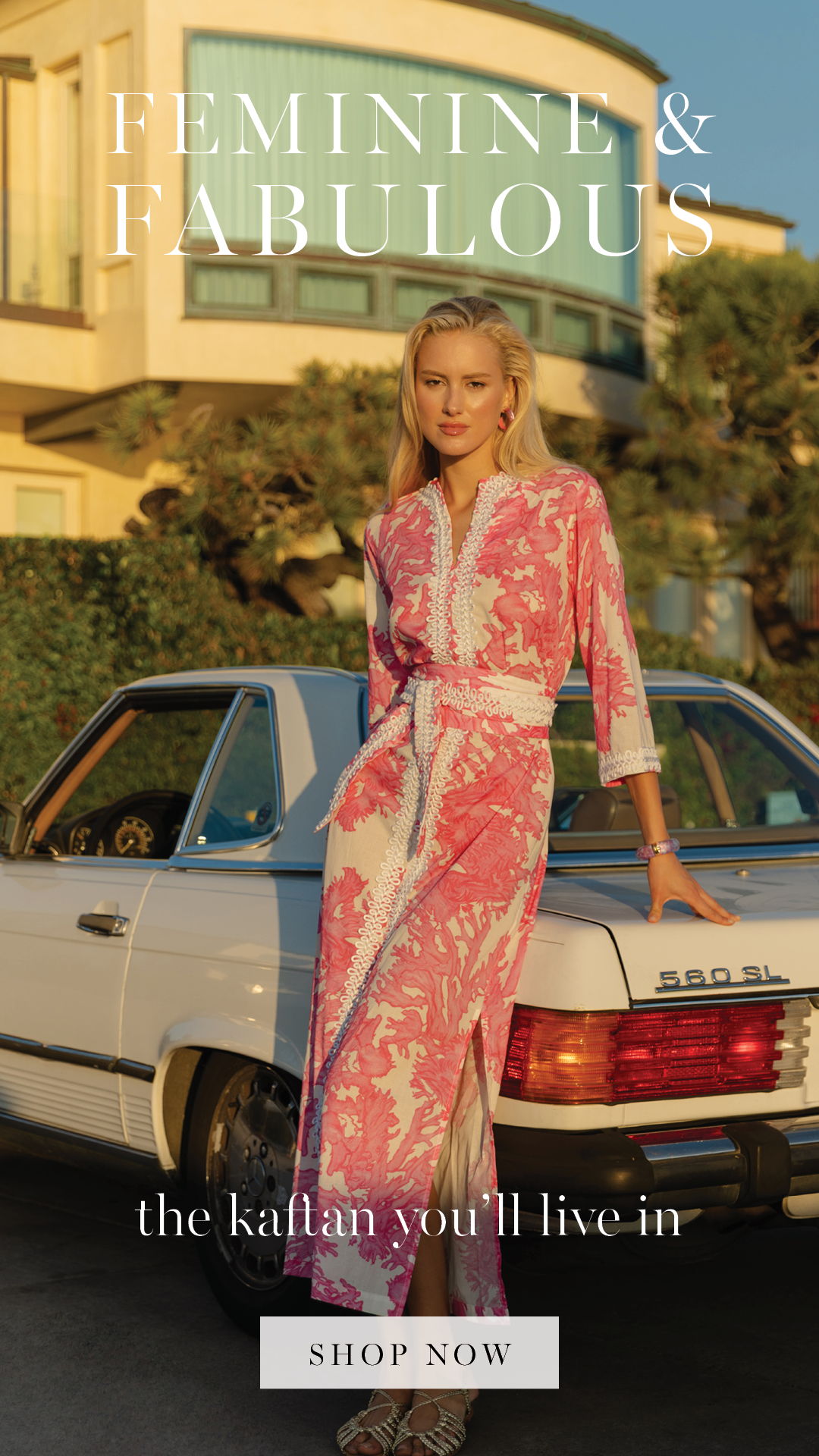 Model in a pink kaftan standing beside a vintage car.