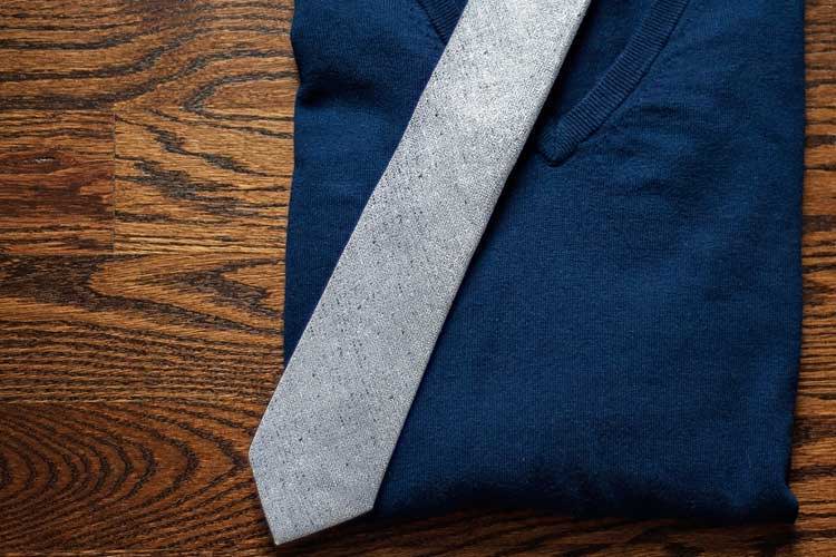 Gray textured tie on navy sweater