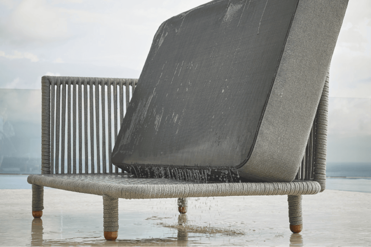 Quick-dry outdoor cushion draining water from a commercial-grade woven lounge chair