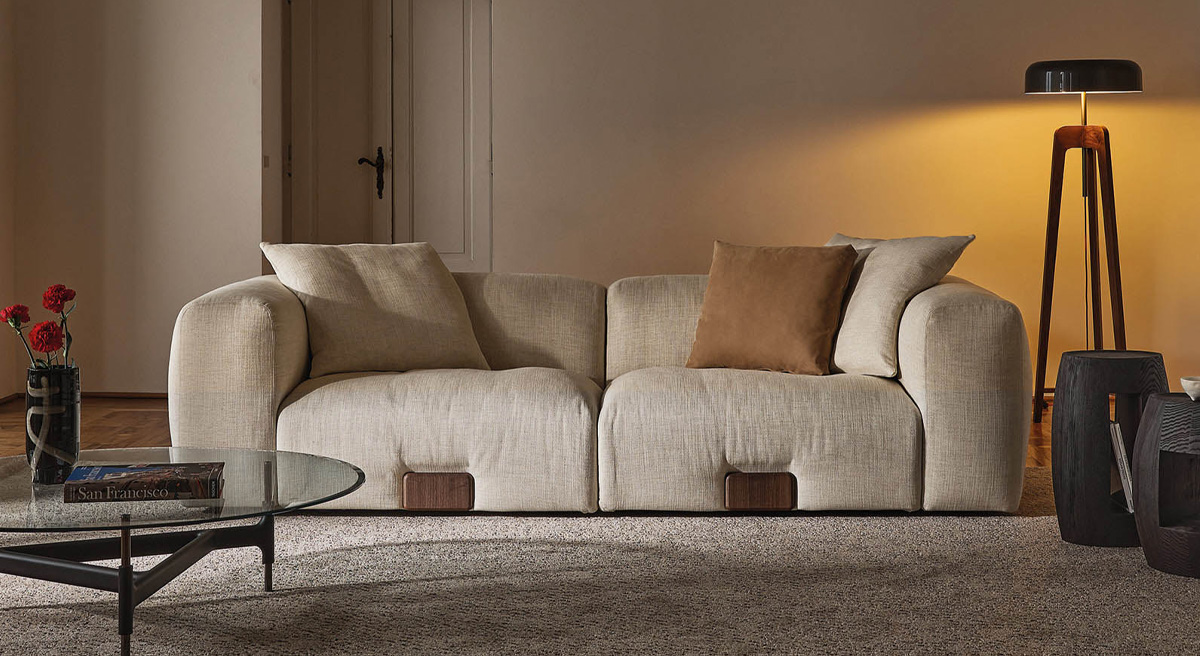 A cozy beige Porada sofa with cushions in a modern living room setting.