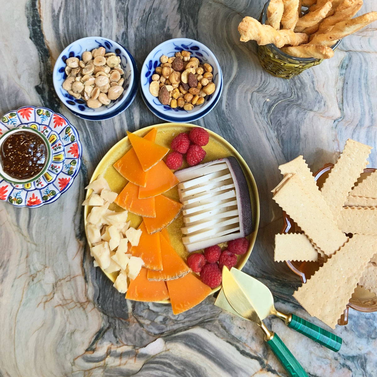 Spread of cheese, crackers and nuts on decorative platters