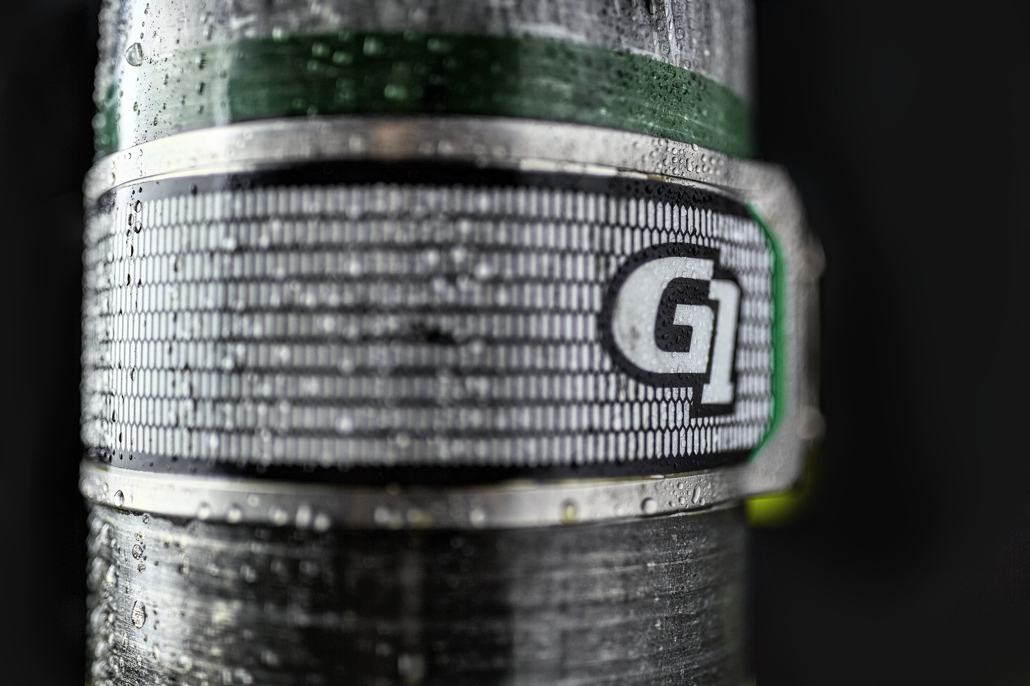 Close-up of a wet container with a logo and textured surface.