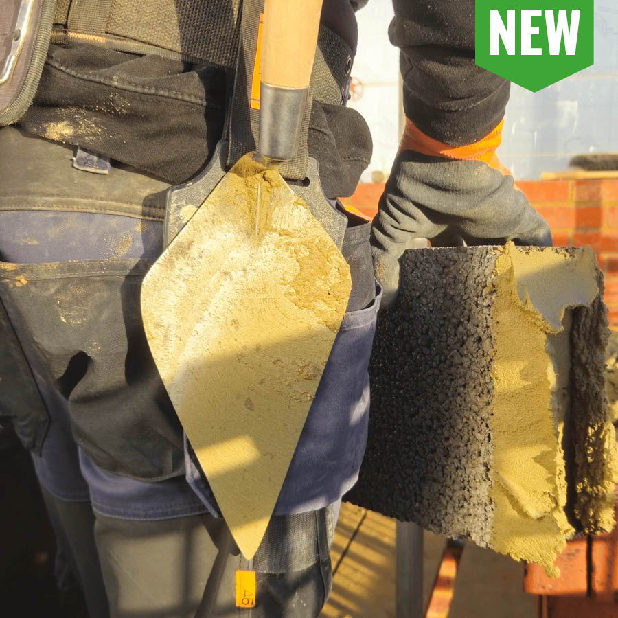 Person holding a trowel and sponge, wearing work gloves and a tool belt.