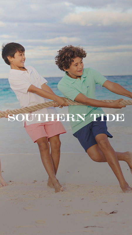 Two boys playing tug-of-war on the beach. Text overlay: 