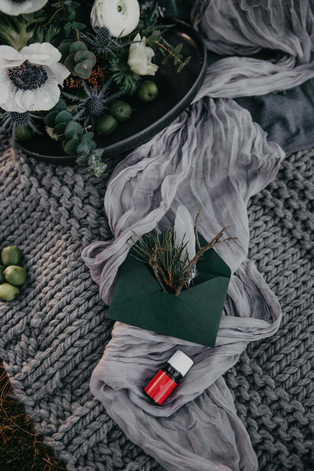 a bouquet of flowers and a bottle of perfume on a blanket