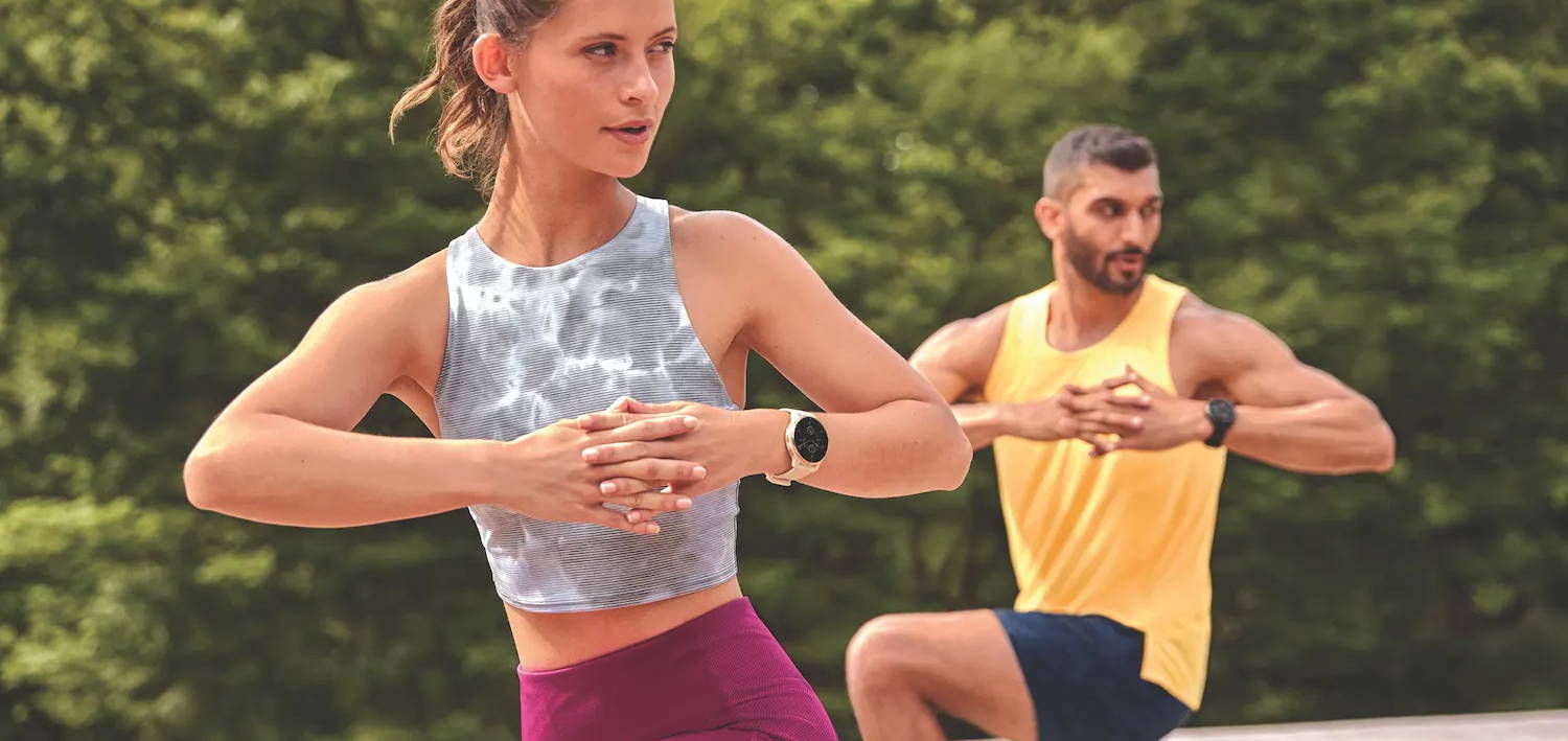 A woman and man working out outside while wearing Garmin Venu 2 Plus GPS watches