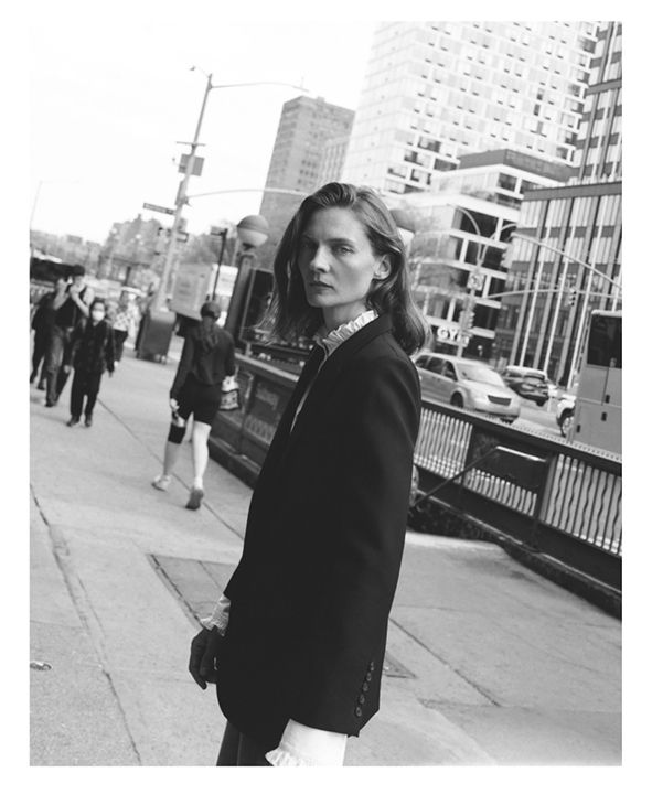 Person in a suit walking on a city street. Black and white photo.
