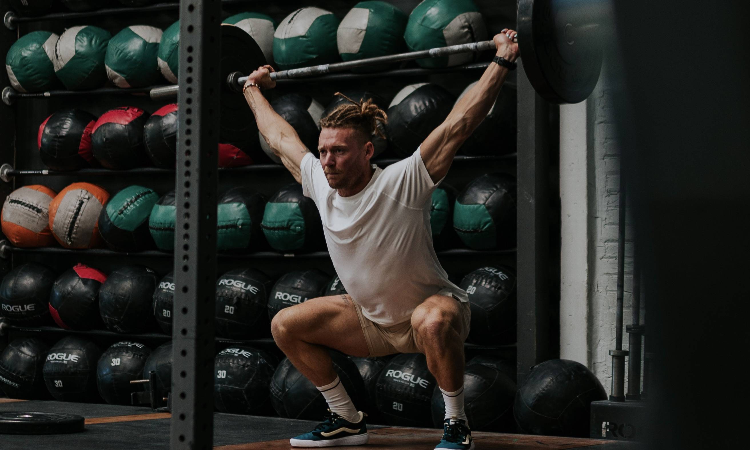 man lifting barbell above his head