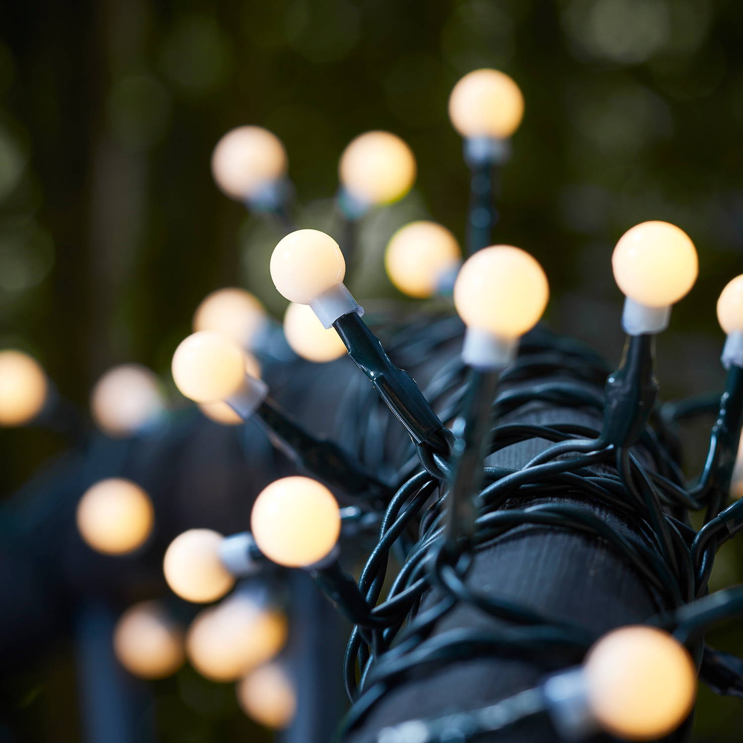 Solar berry lights wrapped around outdoor seating in a summer evening setting