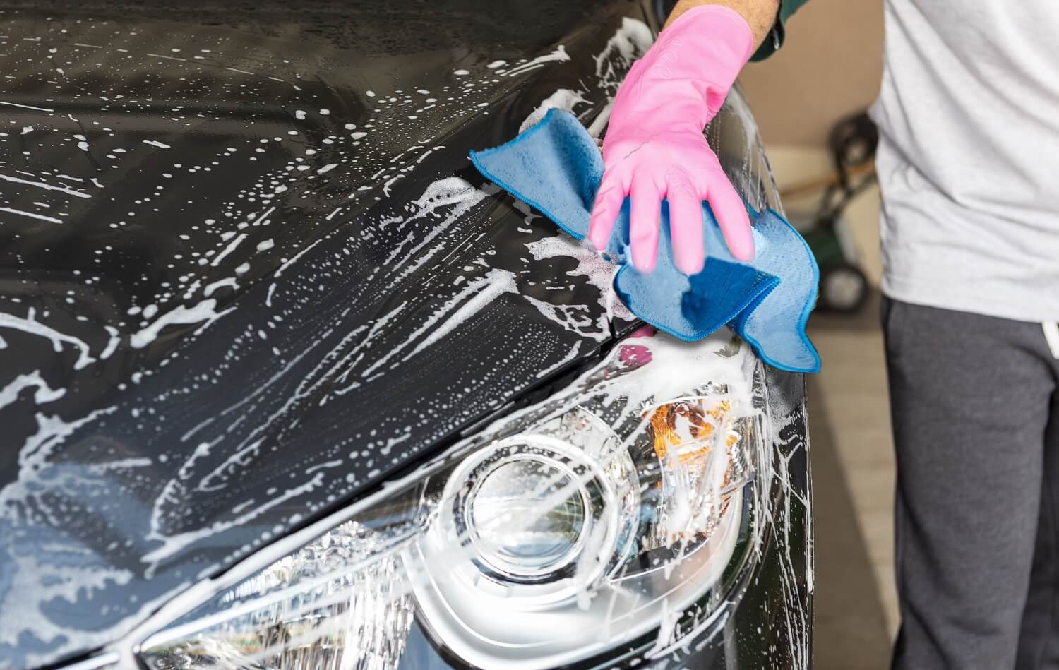 person cleaning car with microfiber car towel