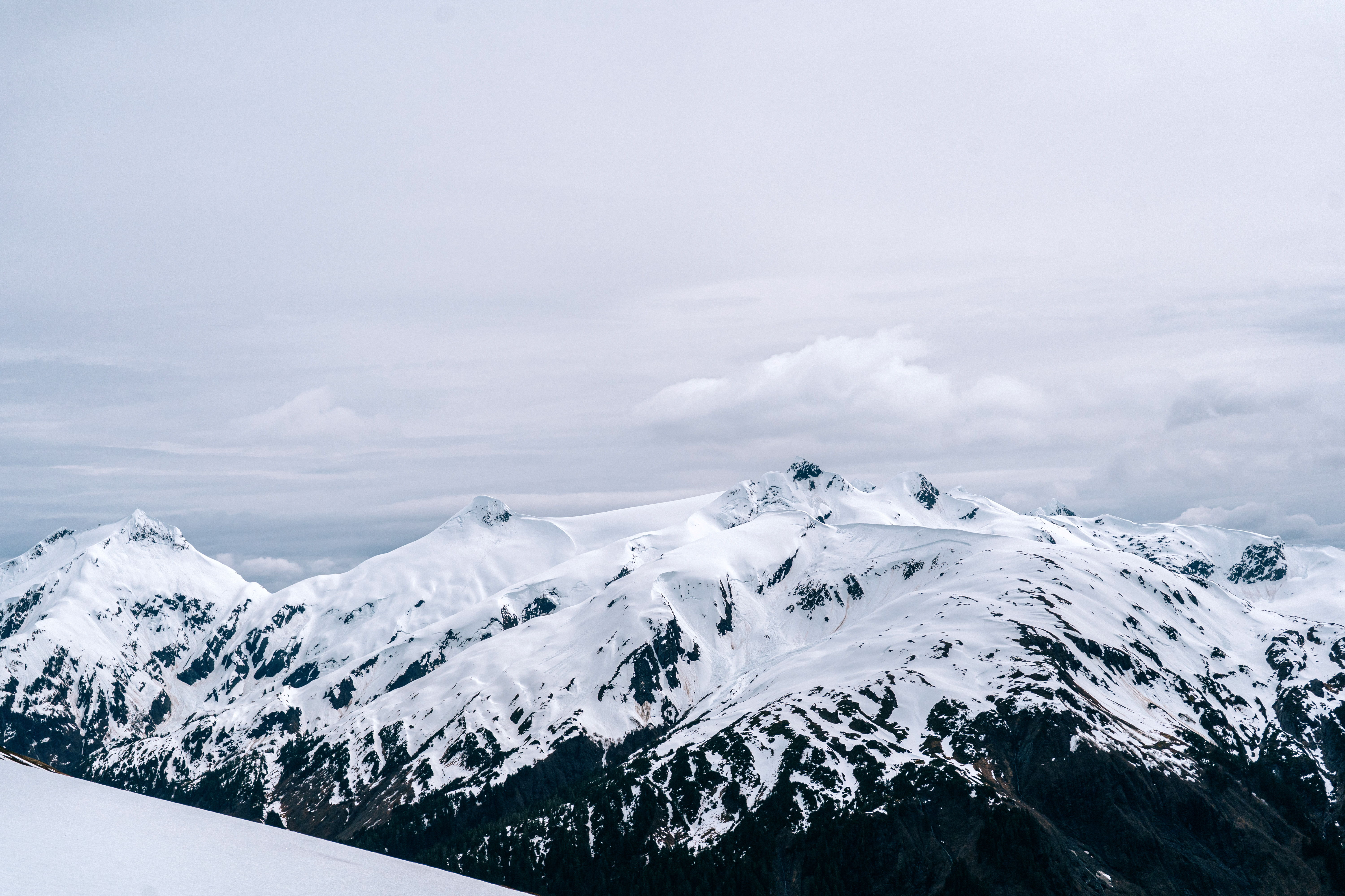 Snow-covered mountains under a cloudy sky.