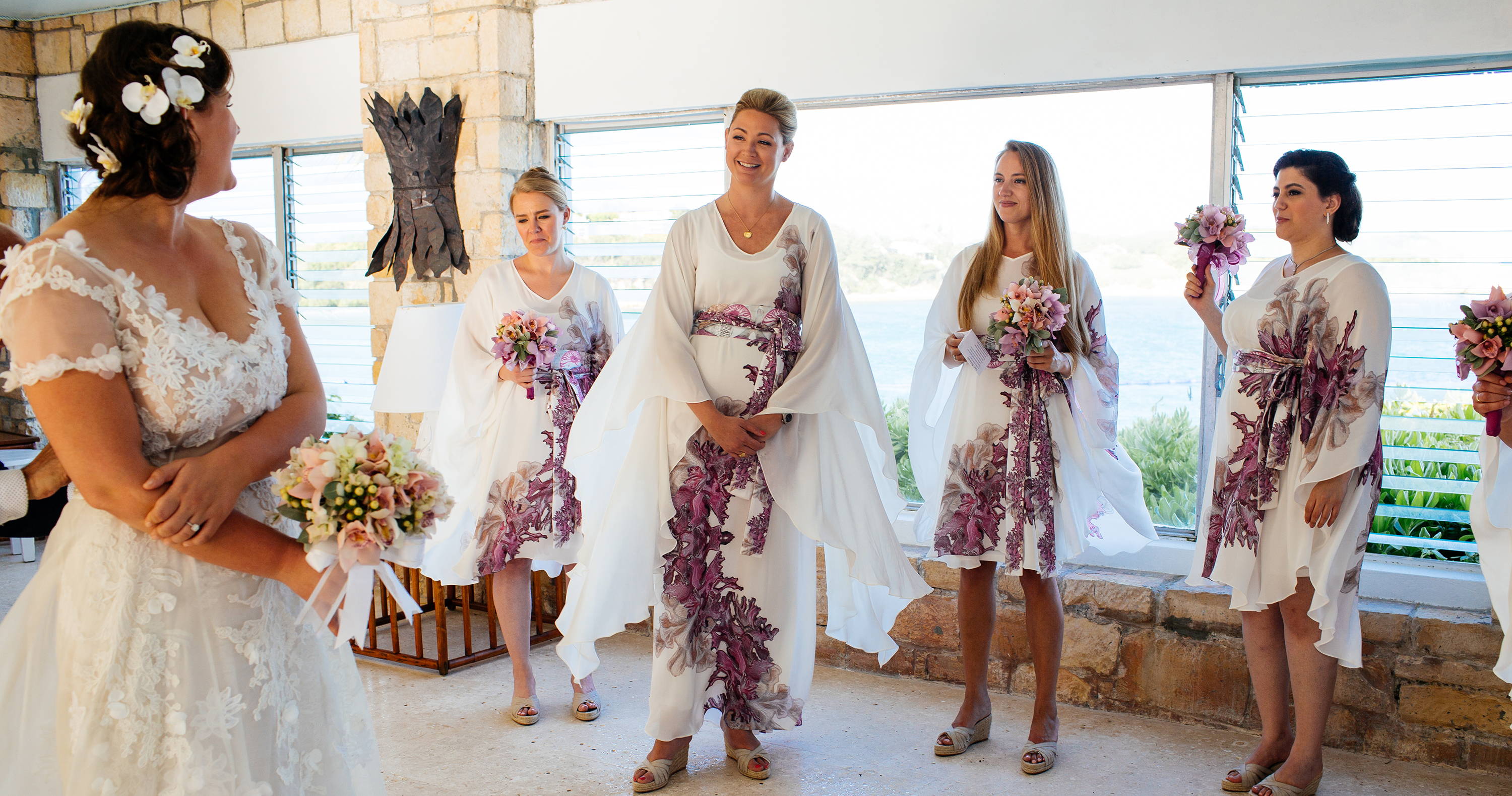 Bridesmaids wearing custom coral silk bridesmaids dresses at a Caribbean destination wedding by Ala von Auersperg