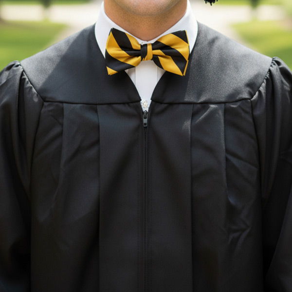 Graduate wearing a black and gold striped bow tie with gown