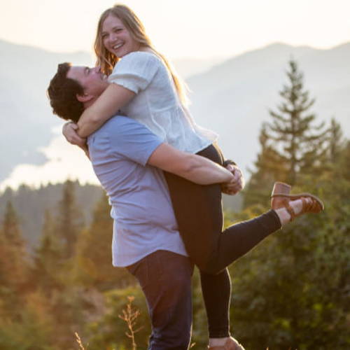 Couple posing together in a scenic mountain background