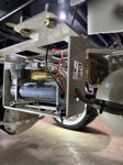 Close-up of HornBlasters air compressor in custom white HB-logo bracket under vehicle