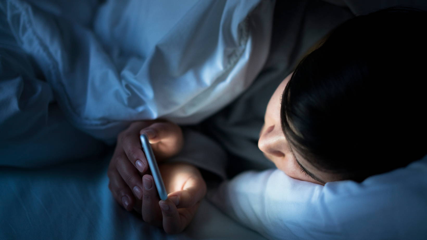 person on phone in bed