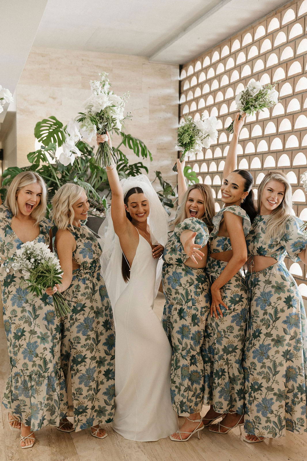 Bride and Bridal Party raising bouquets