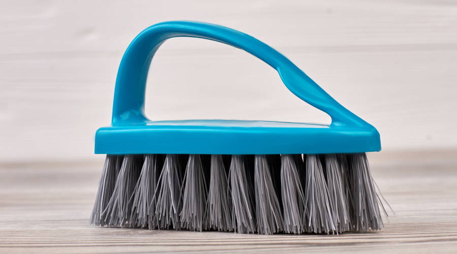 a plastic handle and bristle scrubbing brush