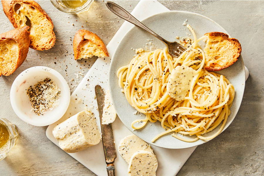 Pasta on a plate tossed in a cheesy buttery and black pepper sauce