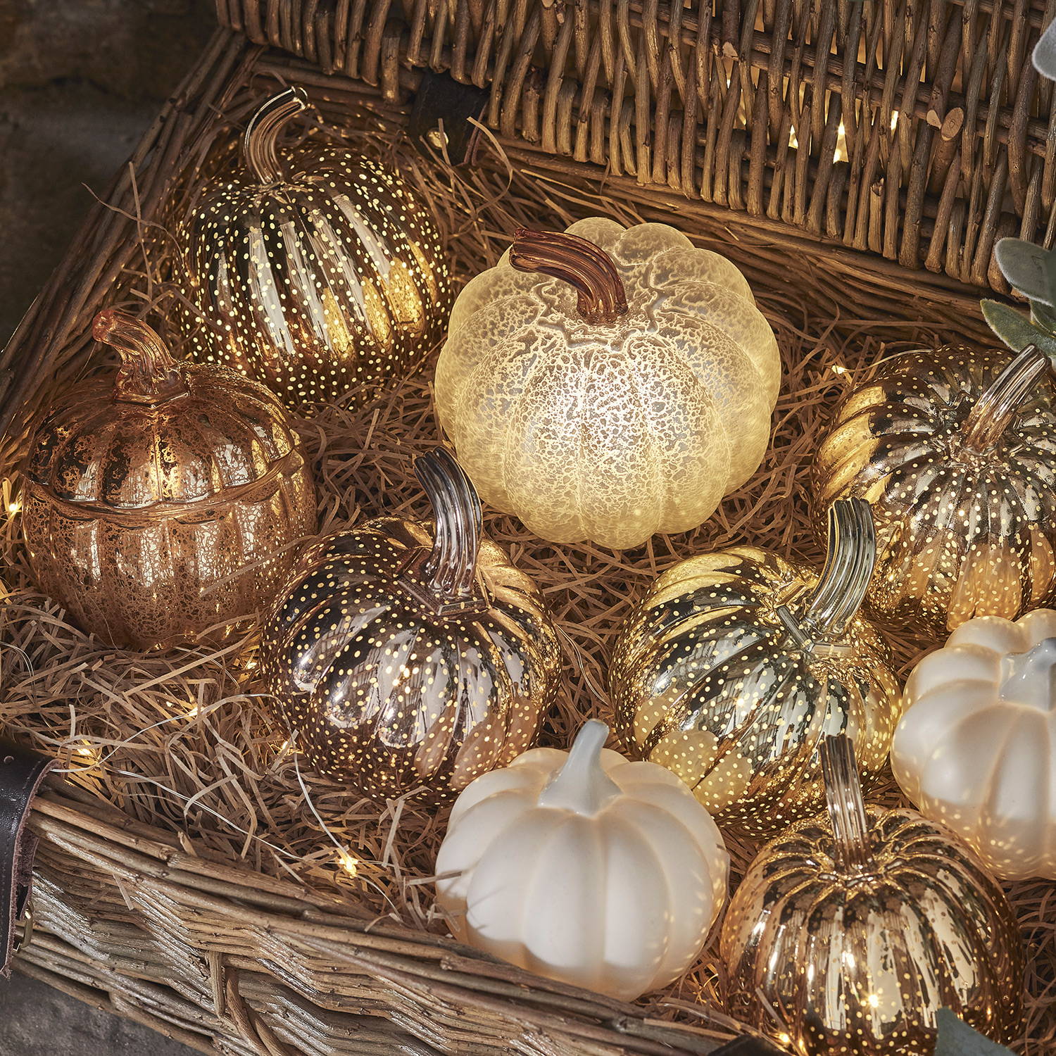 A hamper filled with numerous light up pumpkins of different colours.