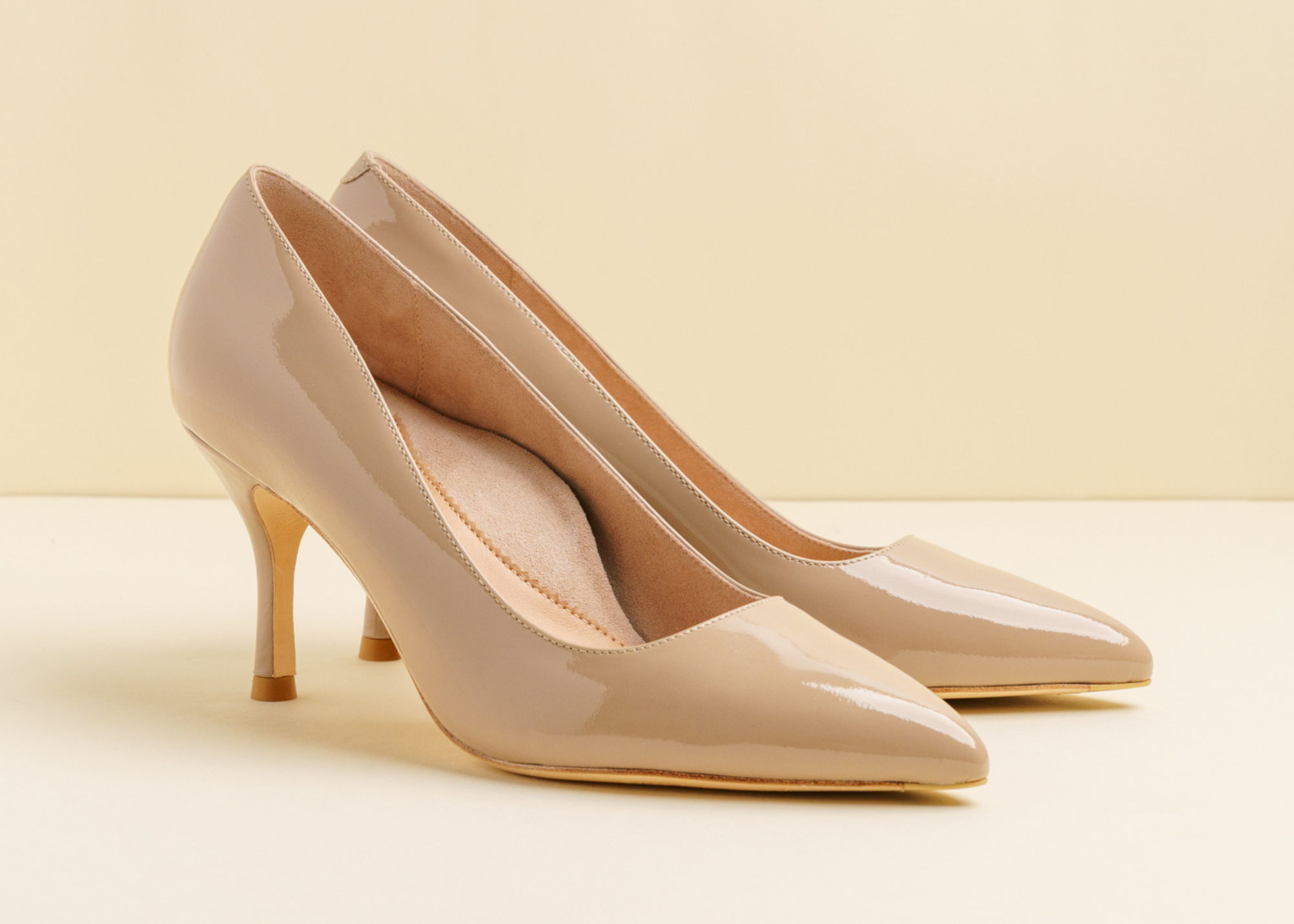 Beige high-heeled shoe on a light background.