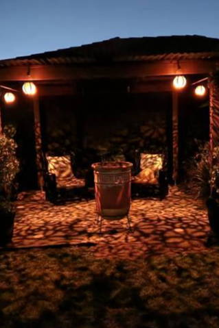 Dimly lit outdoor seating area with plants and a table.