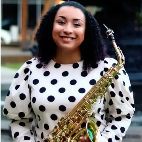 Alexia McLean holding an alto saxophone