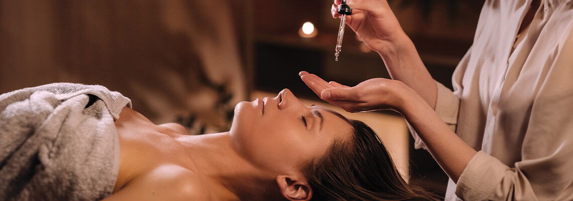 A woman receiving a facial treatment in a spa setting.