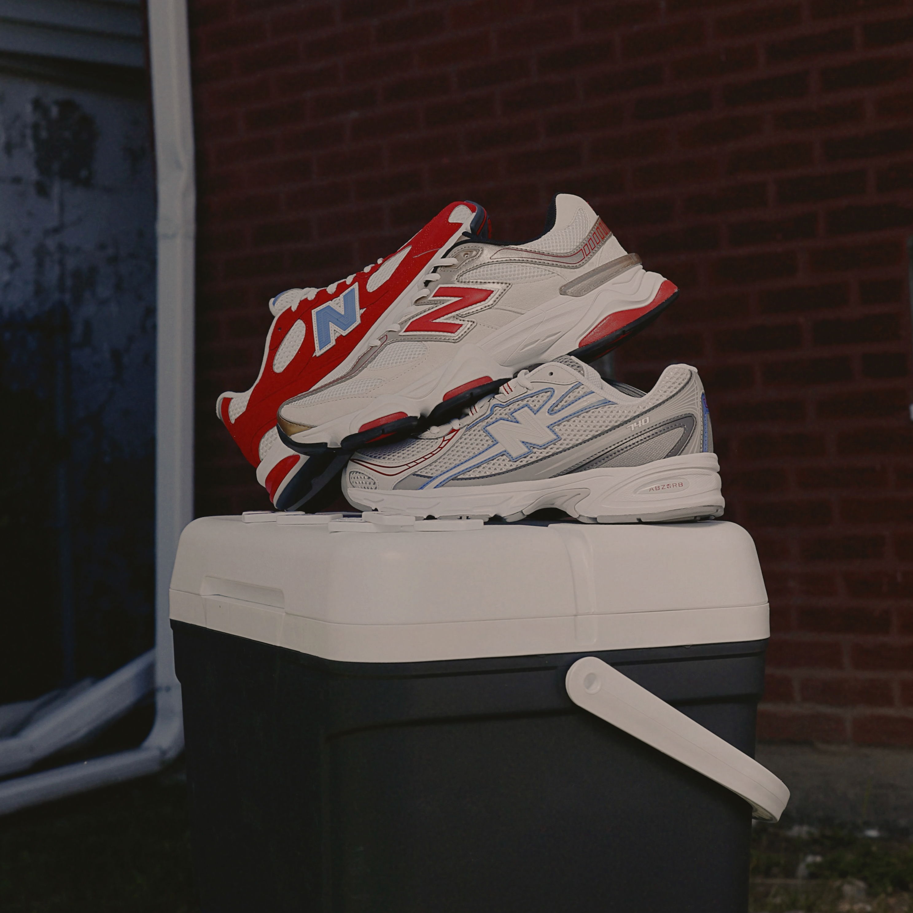 A pair of sneakers resting on a trash can.