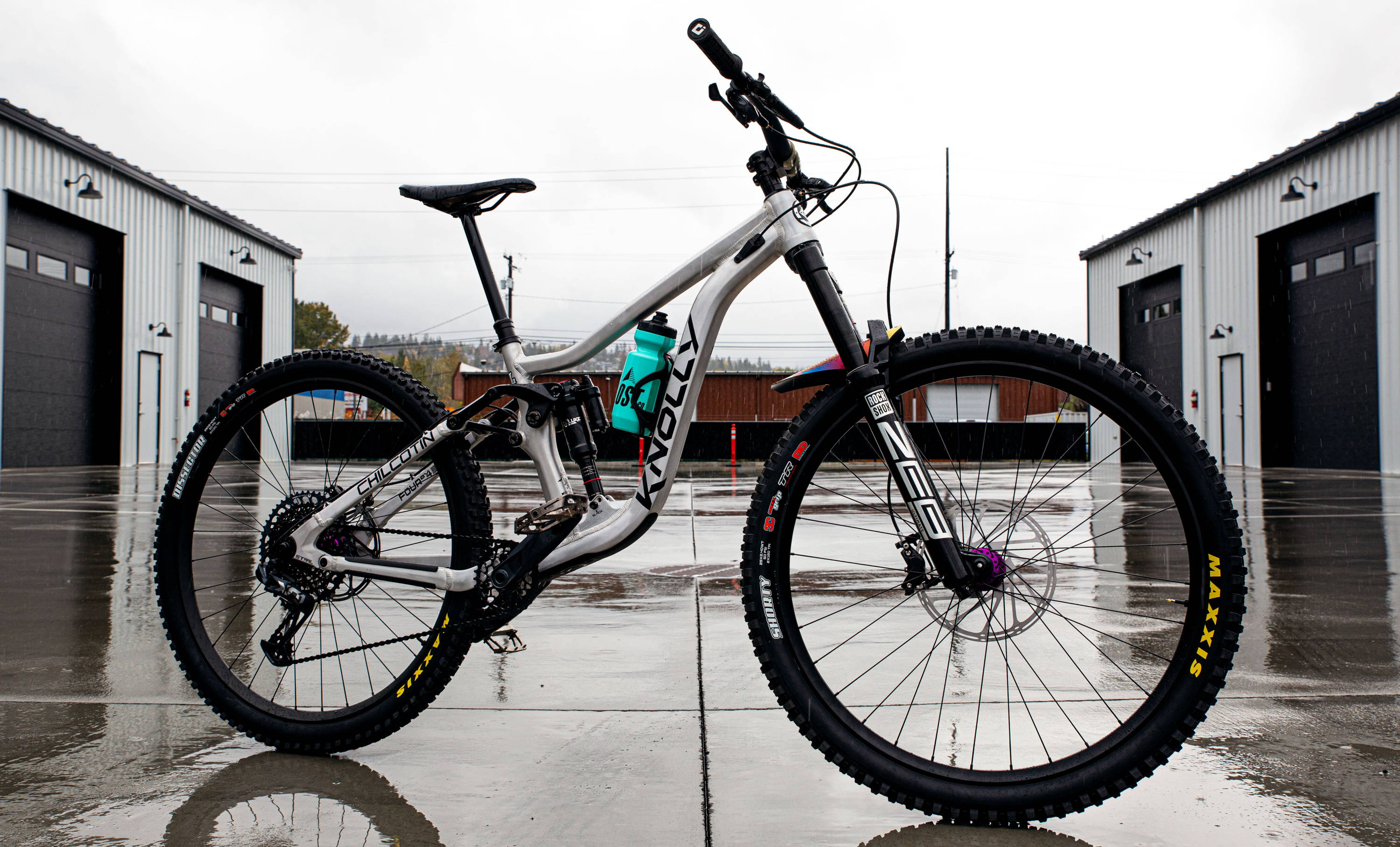 Knolly Chilcotin with RockShox ZEB Super Deluxe Ultimate Maxxis Tires SRAM Drivetrain on wet pavement in industrial space