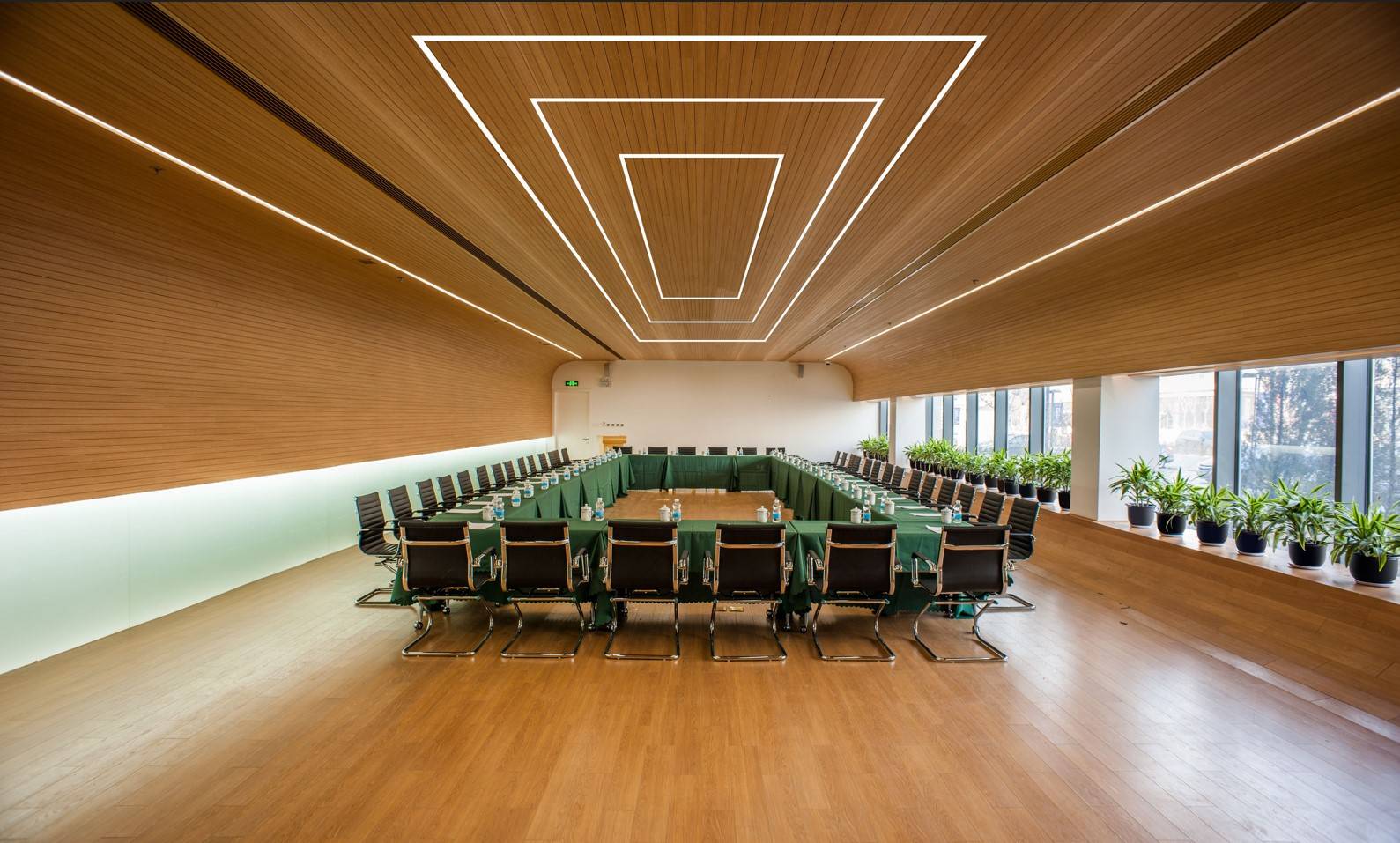Recessed LED linear lights installed on ceiling of a large conference room.