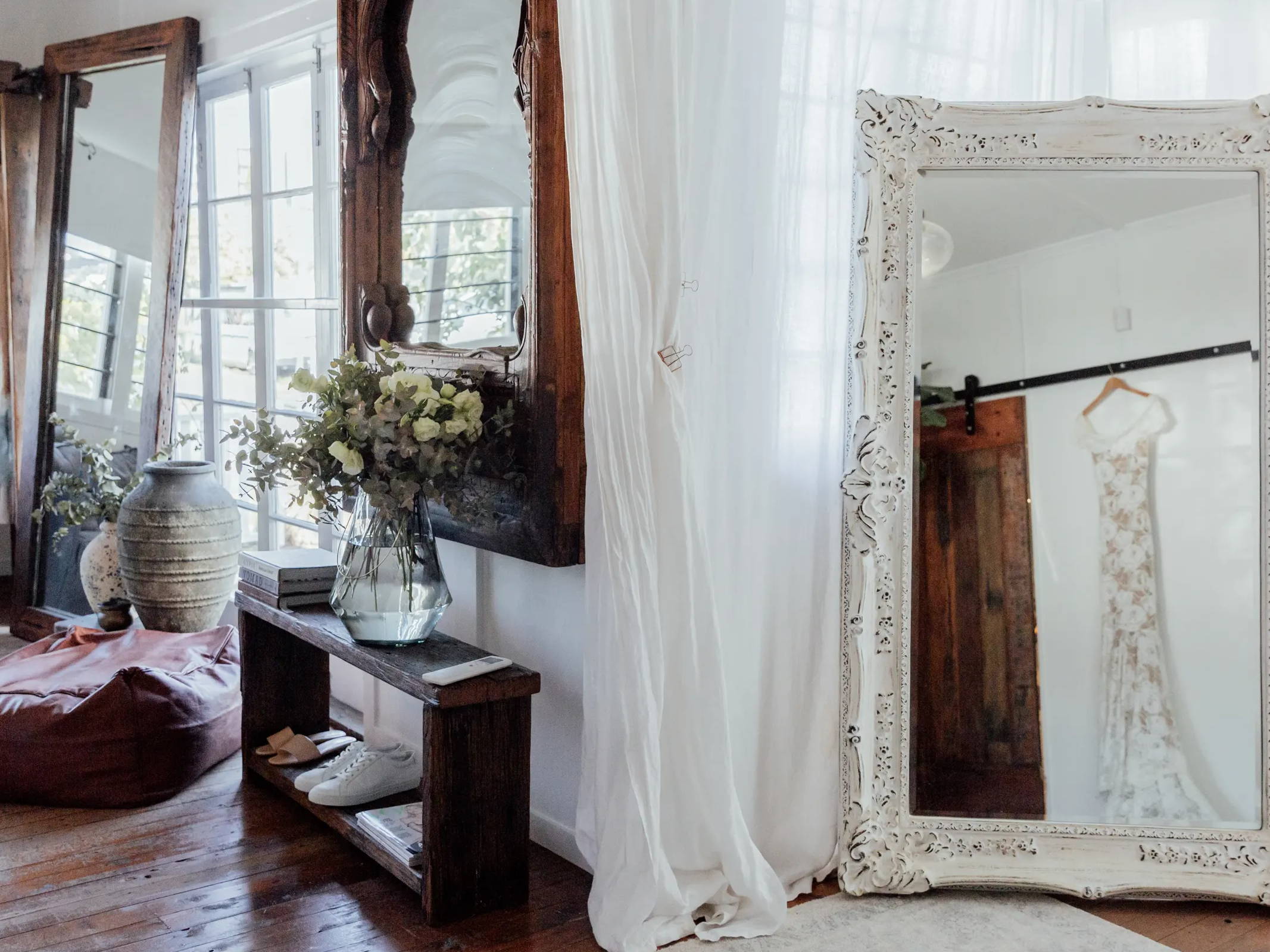 Three large mirrors and bohemian decor inside bridal shop