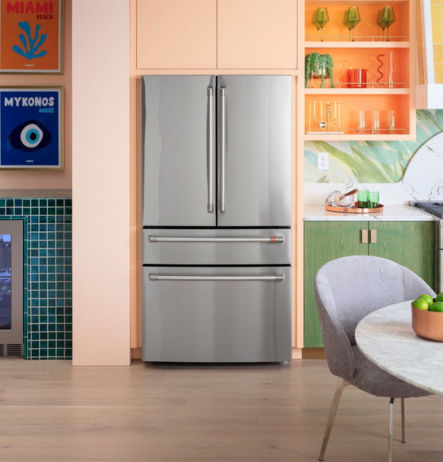A modern stainless steel refrigerator in a colorful kitchen setting.