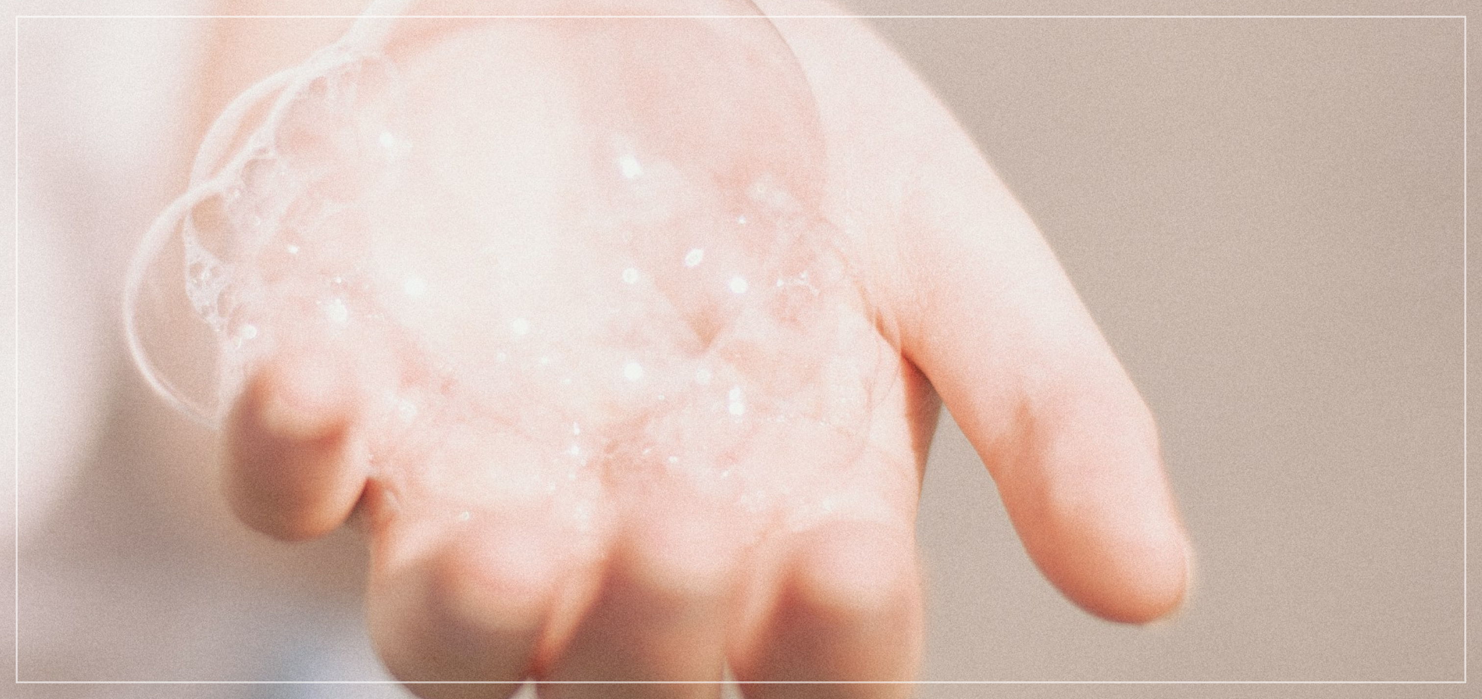 A hand holding several large soap bubbles