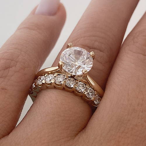 Woman wearing a solitaire engagement ring paired with the 11 Stone Lab Grown Diamond Band by MiaDonna