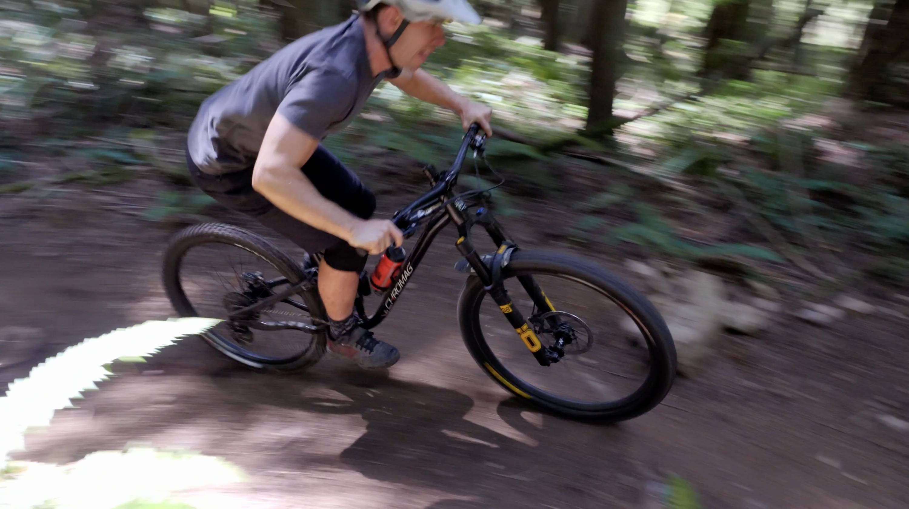 mountain biker riding through bellingham woods on chromag full suspension bike with ohlins fork
