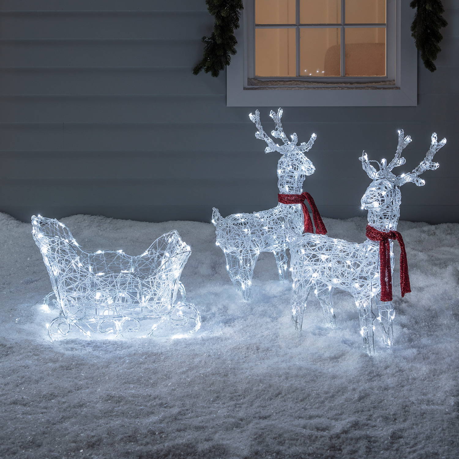 Light up reindeer and sleigh Christmas duo illuminating an icy glow over snow